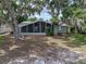 Charming home with a screened porch surrounded by lush greenery and mature trees at 914 Mangham Rd, Babson Park, FL 33827