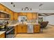 Modern kitchen featuring stainless steel appliances, tile backsplash, wooden cabinets, and ample counter space, perfect for cooking at 914 Mangham Rd, Babson Park, FL 33827