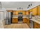 Bright kitchen featuring stainless steel appliances, sleek lighting, and decorative backsplash against warm wood cabinetry at 914 Mangham Rd, Babson Park, FL 33827