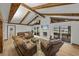 Comfortable living room with exposed beams, a stone fireplace, and views of the lake at 914 Mangham Rd, Babson Park, FL 33827