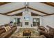 Comfortable living room with exposed beams, a stone fireplace, and views of the lake at 914 Mangham Rd, Babson Park, FL 33827