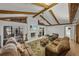 Cozy living room with stone fireplace, beamed ceiling, and water views at 914 Mangham Rd, Babson Park, FL 33827