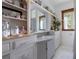 Quaint bathroom featuring vintage cabinets, a sink, and decorative shelving, accented by a bright window at 103 Se Tuscawilla Ave, Ocala, FL 34471