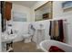 Classic bathroom featuring a vintage clawfoot tub, unique sink and framed mirror at 103 Se Tuscawilla Ave, Ocala, FL 34471