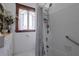 Classic bathroom featuring a shower-tub combo, white tile, wooden window trim, and vintage-inspired fixtures at 103 Se Tuscawilla Ave, Ocala, FL 34471