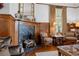 Living room has a stunning fireplace with marble surround, wooden paneling, and period furniture at 103 Se Tuscawilla Ave, Ocala, FL 34471