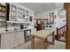 A well-lit eat-in kitchen with an island, a unique display cabinet and access to a staircase at 103 Se Tuscawilla Ave, Ocala, FL 34471