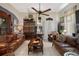 An inviting living room with leather sofas, a decorative ceiling fan, and a unique display cabinet at 103 Se Tuscawilla Ave, Ocala, FL 34471