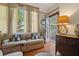 Charming living room featuring hardwood floors, large windows, and comfortable seating creating a warm, inviting atmosphere at 103 Se Tuscawilla Ave, Ocala, FL 34471