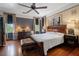 Elegant main bedroom featuring hardwood floors, large windows, and a stylish bed with vintage furnishings, exuding comfort at 103 Se Tuscawilla Ave, Ocala, FL 34471