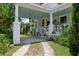 Charming front porch with white columns, lush greenery, and a classic hanging lantern at 103 Se Tuscawilla Ave, Ocala, FL 34471