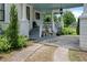 Charming front porch with elegant white columns, patterned walkway, and lush, verdant landscaping at 103 Se Tuscawilla Ave, Ocala, FL 34471