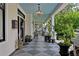 Inviting front porch with a decorative chandelier, checkered flooring, and lush potted plants at 103 Se Tuscawilla Ave, Ocala, FL 34471