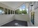 Bright sunroom with large windows offering views of lush greenery and a unique tiled floor, perfect for relaxation at 103 Se Tuscawilla Ave, Ocala, FL 34471