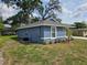 Exterior view of the home showcasing its blue siding, and well maintained surroundings and green lawn at 1121 W 9Th St, Lakeland, FL 33805