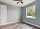 This bedroom features a closet, wood-look flooring, a ceiling fan, and a window at 1264 Buckeye Ne Rd, Winter Haven, FL 33881