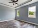 A spacious bedroom features neutral walls, wood-look flooring, a ceiling fan, and two windows at 1264 Buckeye Ne Rd, Winter Haven, FL 33881