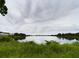 Scenic view of the tranquil pond, reflecting the cloudy sky above at 1264 Buckeye Ne Rd, Winter Haven, FL 33881