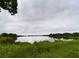 Picturesque view of the pond surrounded by lush green vegetation and trees at 1264 Buckeye Ne Rd, Winter Haven, FL 33881