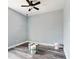 Unfinished room shows empty space with wood-look flooring, a ceiling fan, and fresh paint at 1264 Buckeye Ne Rd, Winter Haven, FL 33881