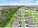 Wide aerial view of a community with neatly arranged homes near a natural woodland and pond area at 1274 Pintail Pl, Lakeland, FL 33813
