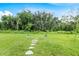 Lush backyard featuring stepping stones, trees, and ample green space at 1274 Pintail Pl, Lakeland, FL 33813