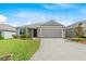 Inviting home featuring a manicured lawn and a driveway leading to a two-car garage at 1274 Pintail Pl, Lakeland, FL 33813