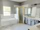 Bathroom featuring a bathtub, framed shower, gray vanity cabinets, and plenty of space at 130 Prima Dr, Kissimmee, FL 34759