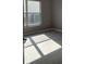 Bedroom features a large window for natural light, neutral walls, and light wood flooring at 130 Prima Dr, Kissimmee, FL 34759
