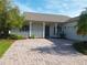 Inviting home featuring a brick driveway and a charming porch with columns at 130 Prima Dr, Kissimmee, FL 34759
