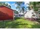 Fenced-in backyard with two sheds, view of the screened-in pool, and lush grass at 1317 Avenue A Se, Winter Haven, FL 33880