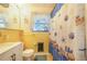 The yellow bathroom features a seashell themed shower curtain, a white sink, and a window at 1317 Avenue A Se, Winter Haven, FL 33880