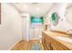 The updated bathroom showcases double sinks, a walk-in tub, and wood-look tile floors at 1317 Avenue A Se, Winter Haven, FL 33880