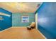This bedroom showcases wood-look tile floors, textured blue walls, and a cozy rocking chair at 1317 Avenue A Se, Winter Haven, FL 33880