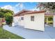 Shed-style structure in backyard, with a tiled awning, white siding, and a concrete walkway at 1317 Avenue A Se, Winter Haven, FL 33880