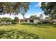 A sprawling one-story home with mature trees, brick chimney and lush green lawn at 1317 Avenue A Se, Winter Haven, FL 33880