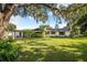 Charming one story home with mature trees, brick chimney, red shutters and lush front lawn at 1317 Avenue A Se, Winter Haven, FL 33880