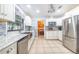 Bright kitchen features stainless steel appliances, white cabinetry, tile backsplash, and tile flooring at 1317 Avenue A Se, Winter Haven, FL 33880