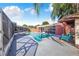 View of the fenced pool with concrete surround, shaded by palm trees and adjacent to screened in porch at 1317 Avenue A Se, Winter Haven, FL 33880