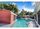 A pristine pool is surrounded by lush greenery and multiple accessory buildings at 1317 Avenue A Se, Winter Haven, FL 33880