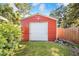 Exterior view of the red shed with a roll-up door and manicured lawn at 1317 Avenue A Se, Winter Haven, FL 33880