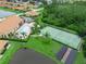Overhead view highlighting the community pool, tennis court, and surrounding landscape at 1349 Innsbruck Ct, Winter Haven, FL 33884