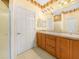Bathroom featuring a double sink vanity with wood cabinets, a large mirror, and stylish wall decor at 1349 Innsbruck Ct, Winter Haven, FL 33884