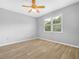 Bright bedroom with wood-look tile flooring and large window with a view of lush greenery at 1349 Innsbruck Ct, Winter Haven, FL 33884