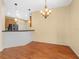 Open dining area featuring a stylish chandelier, wood floors, and neutral color scheme at 1349 Innsbruck Ct, Winter Haven, FL 33884