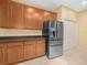 Well-appointed kitchen with stainless steel refrigerator, pantry, and natural wood cabinetry at 1349 Innsbruck Ct, Winter Haven, FL 33884