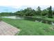 Relaxing pond view with lush green landscaping, brick pavers, and a beautiful reflection of the sky in the water at 1349 Innsbruck Ct, Winter Haven, FL 33884