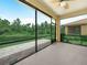 Beautiful screened lanai with views of a tranquil pond, lush landscaping, and outdoor ceiling fan for comfort at 1349 Innsbruck Ct, Winter Haven, FL 33884