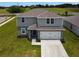 Aerial view of a two-story home with a gray exterior, well-manicured lawn, and attached two-car garage at 137 Piave St, Haines City, FL 33844