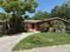 Inviting single-story home showcasing a well-maintained front lawn, mature trees, and a cozy entryway at 1506 Fairbanks St, Lakeland, FL 33805